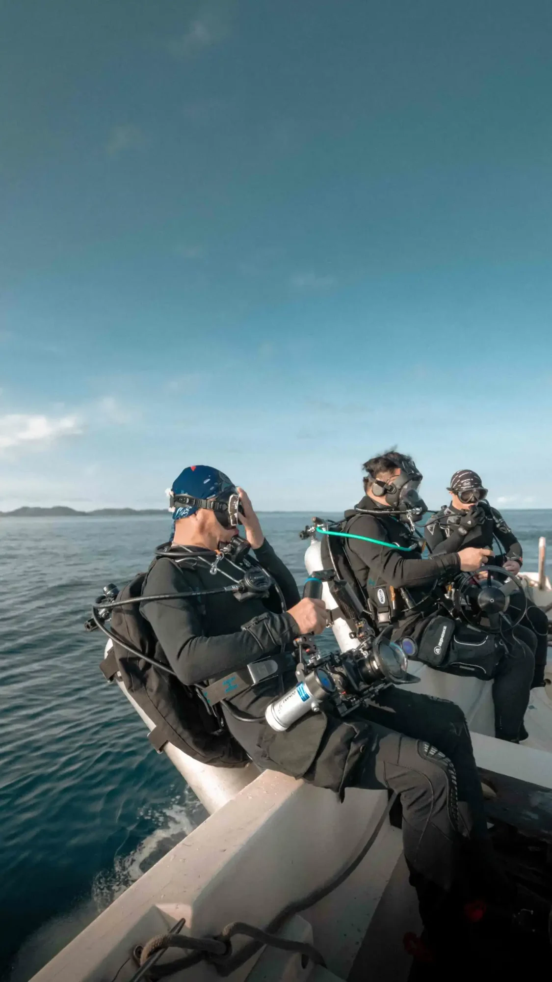 scuba divers in indonesia backrolling into the water